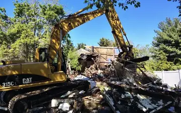 Excavator loading demolition debris for haul-away