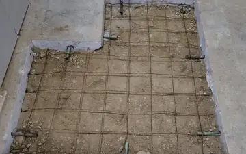 Selective demolition — a section of concrete slab cut out and removed, exposing rebar